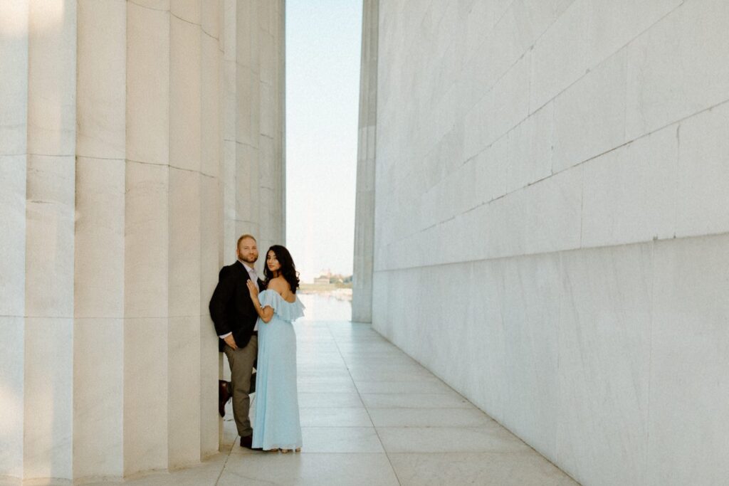 Photo By: Pat Cori Photography of an engaged couple in DC posing next to a hug fluted column. Great things to do in DC is get your engagement photos.