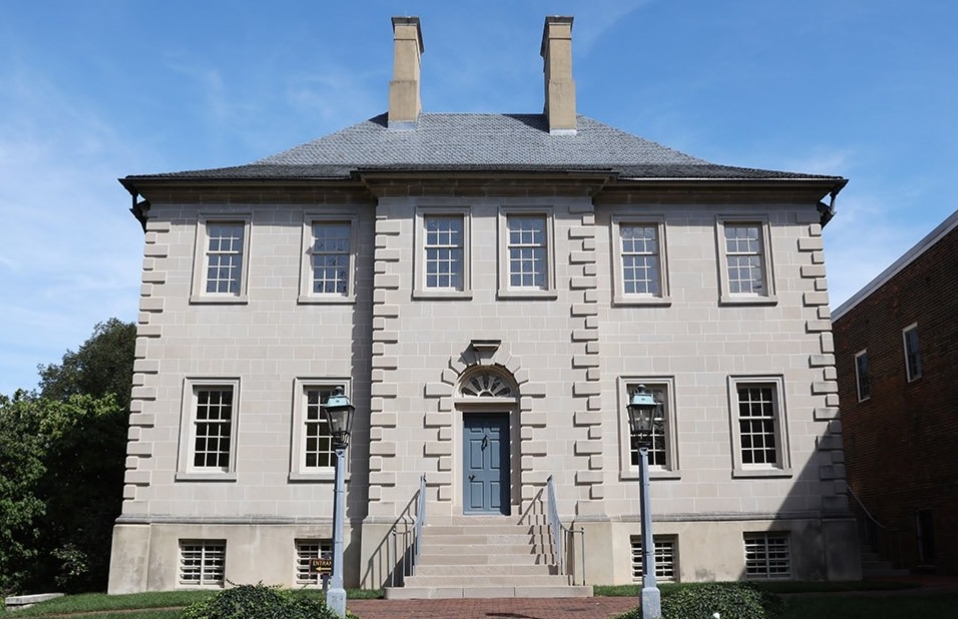 Carlyle House facade of a large gray stone estate with stairs steps leading to the front door. Alexandria Virginia wedding venue.