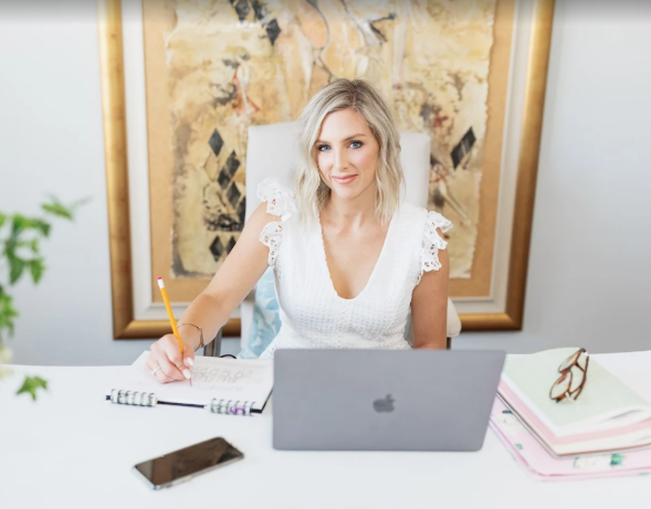 Jesica Ashley photo Event Planner in Washington DC sitting at her desk and laptop planner her next wedding event. 