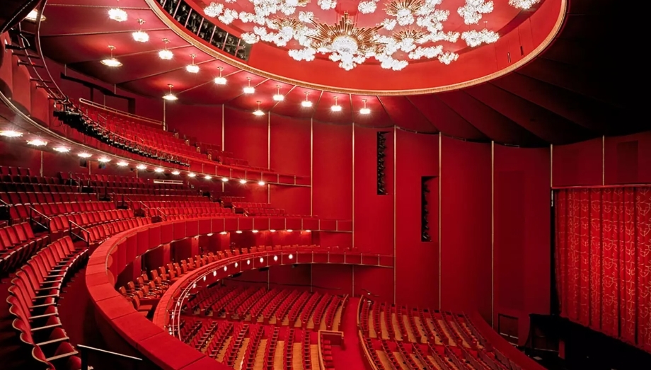 Photo of The Kennedy Center Theater in red with rows of seating in a circular shape.