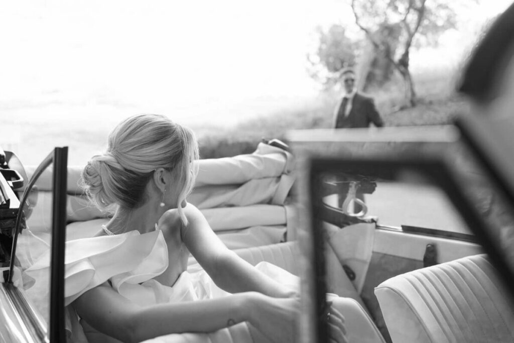 Photo by Pat Cori Photography of a bride in a car looking at the groom. Wedding places in Virginia for luxury weddings.