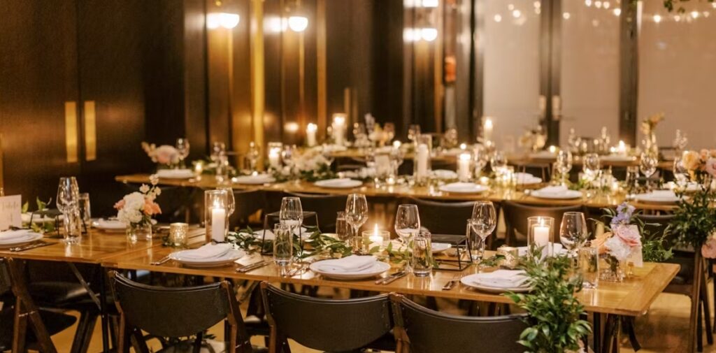 Reception area at District Winery in DC with long tables adorned with glass stemware and china. A DC wedding venue.