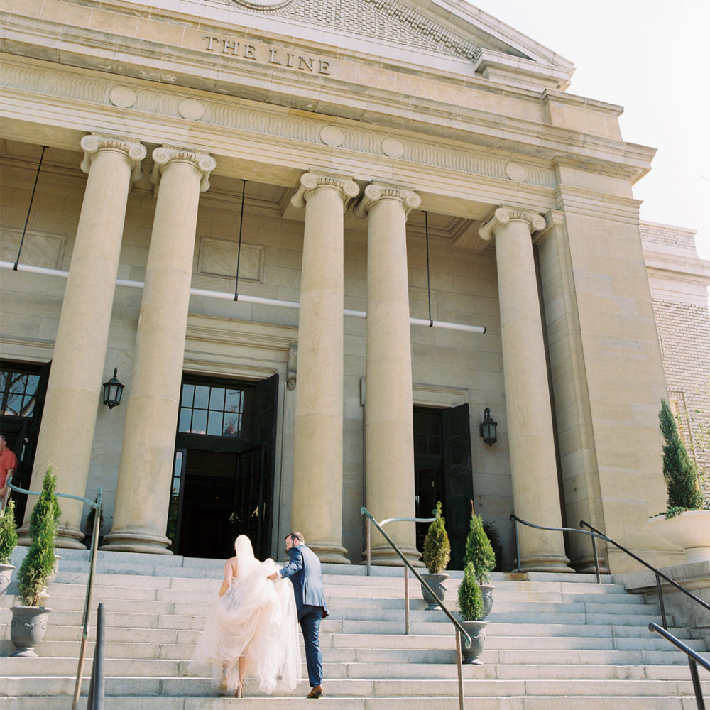 Photo of a Bride and Groom walking up the Steps at The Line Hotel a DC wedding venue.