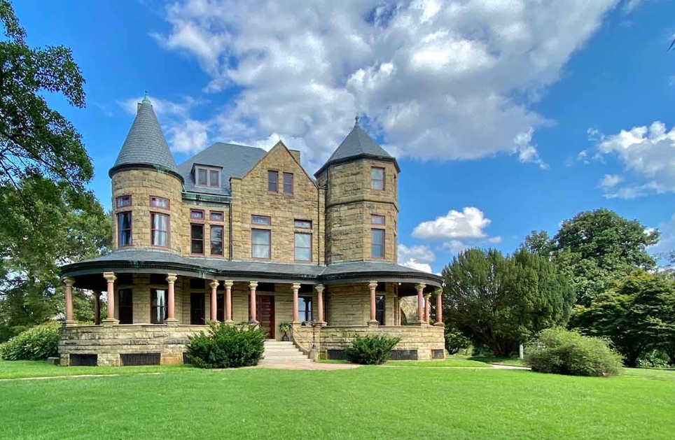 Photo of the Maymont with exposed brick, iron beams surrounded by lush greenery. This is a Richmond Virginia wedding venue.