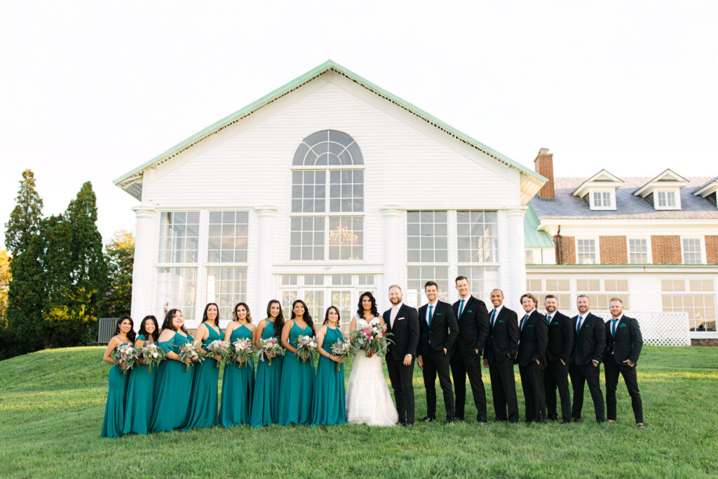 wedding couple posing with their wedding party at the manor at raspberry plain manor in leesburg va