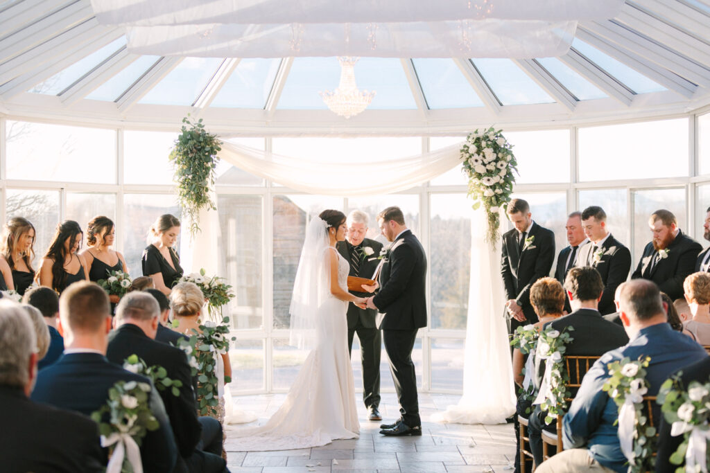 couple during ceremony inside the glass room at West Manor estate