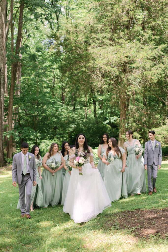 bridesmaids walking behind the bride in the gardens