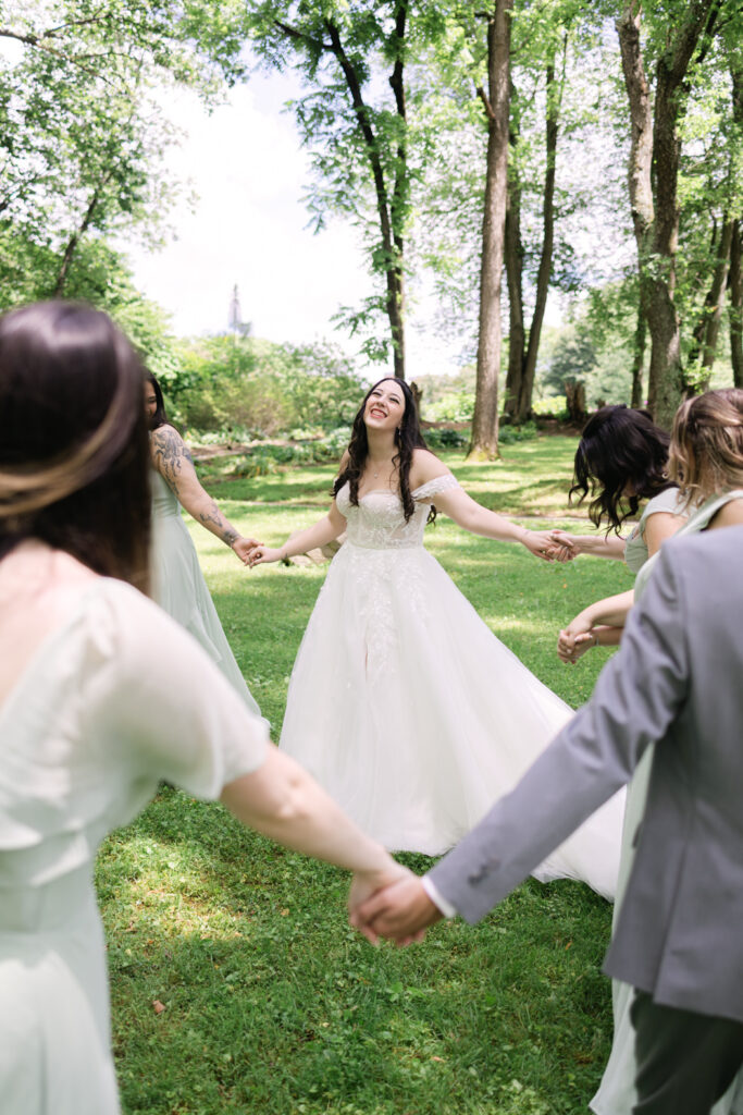 bride dancing with her bridesmaids holding hands