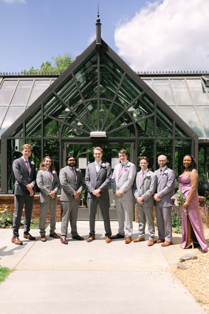 groom and groomsmen in front of greenhouse