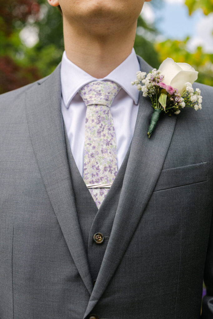 white rose boutonniere with green and lavender tones