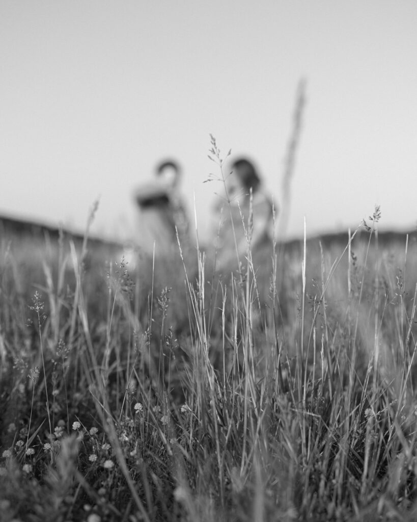 couple cheering at sunset at explore park for engagement pictures in black and white