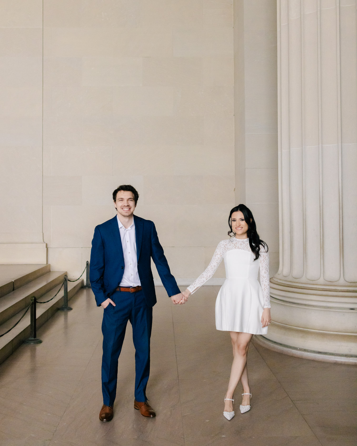 couple holding hands inside lincoln memorial in washington dc