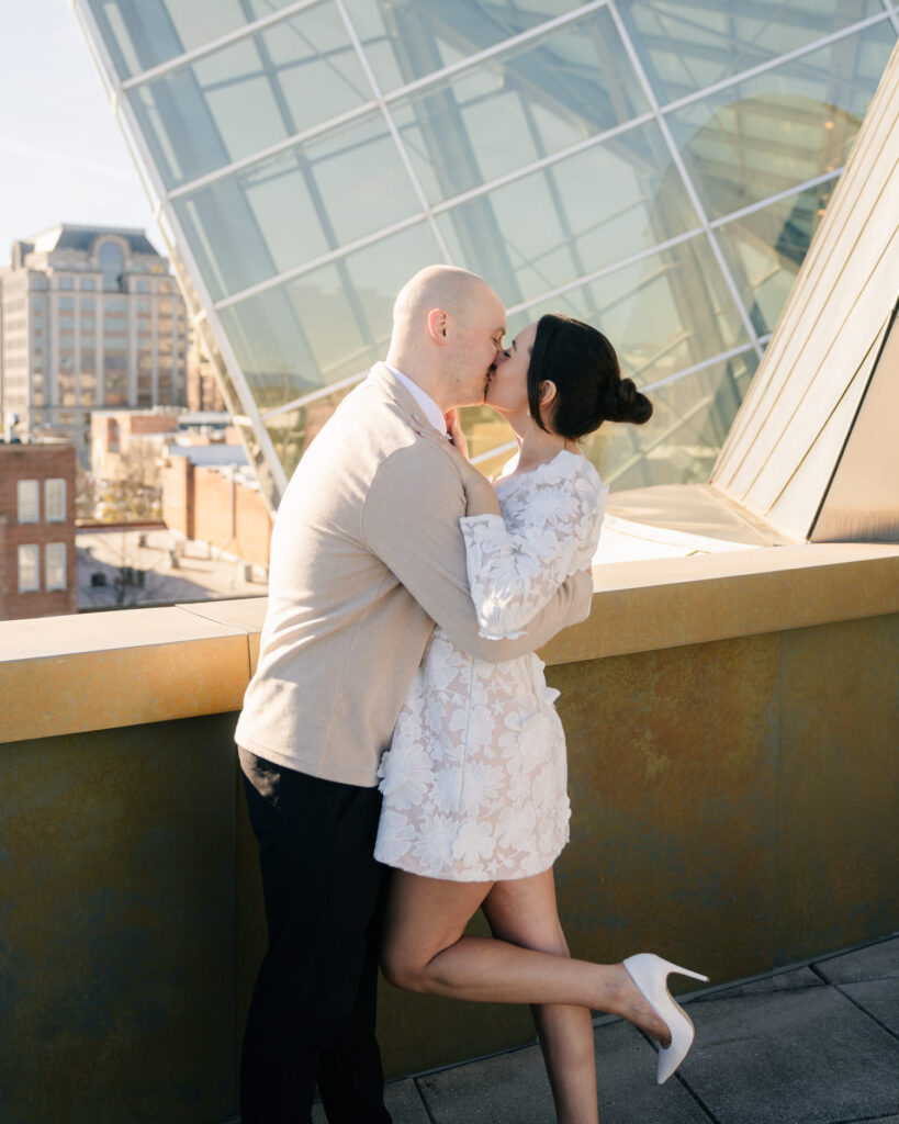 couple kissing in front of the taubman museum for engagement photos in roanoke va