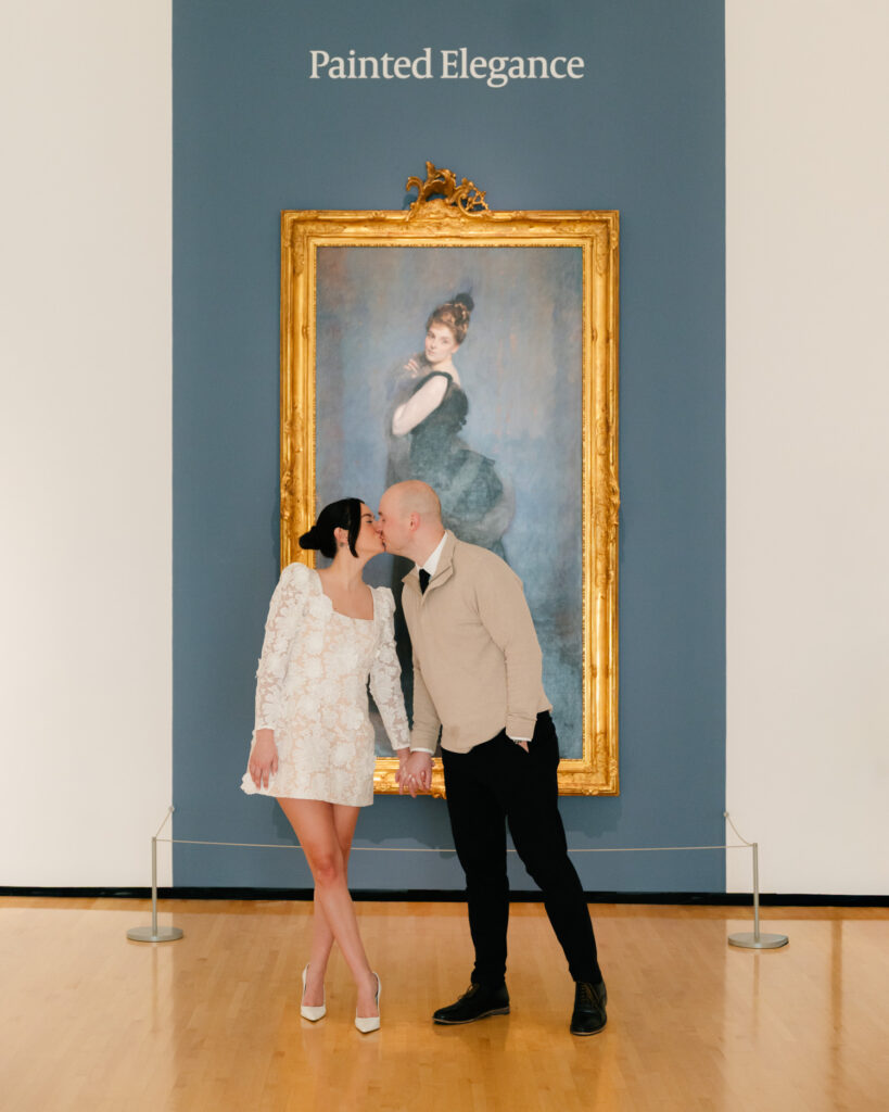 couple kissing in front of painting at the taubman museum for engagement photos