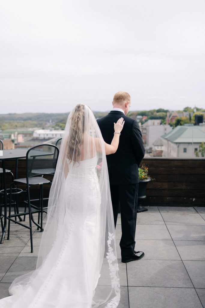 bride's tapping on groom's shoulder during an intimate first look at The Virginian Hotel wedding in Lynchburg, VA
