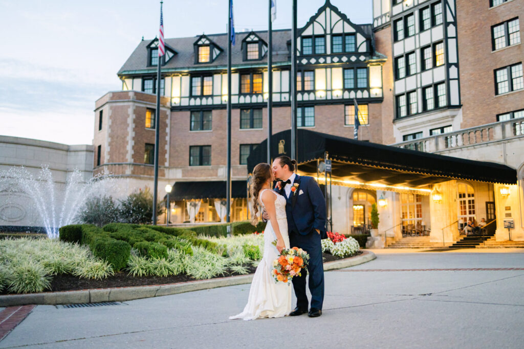 Newlywed couple kissing in front of the historic Hotel Roanoke at dusk, highlighting a classic Virginia location suited for wedding venues for small weddings, photographed by Pat Cori Photography