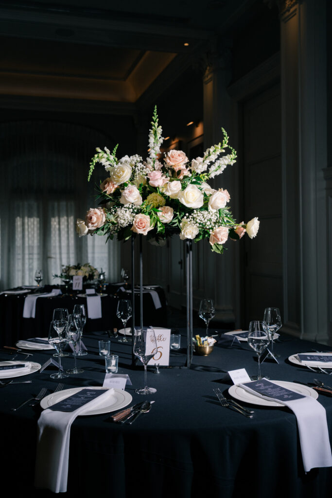 Elegant reception table with tall floral centerpiece, black linens, and candlelight inside the ballroom at The Virginian Hotel wedding in Lynchburg