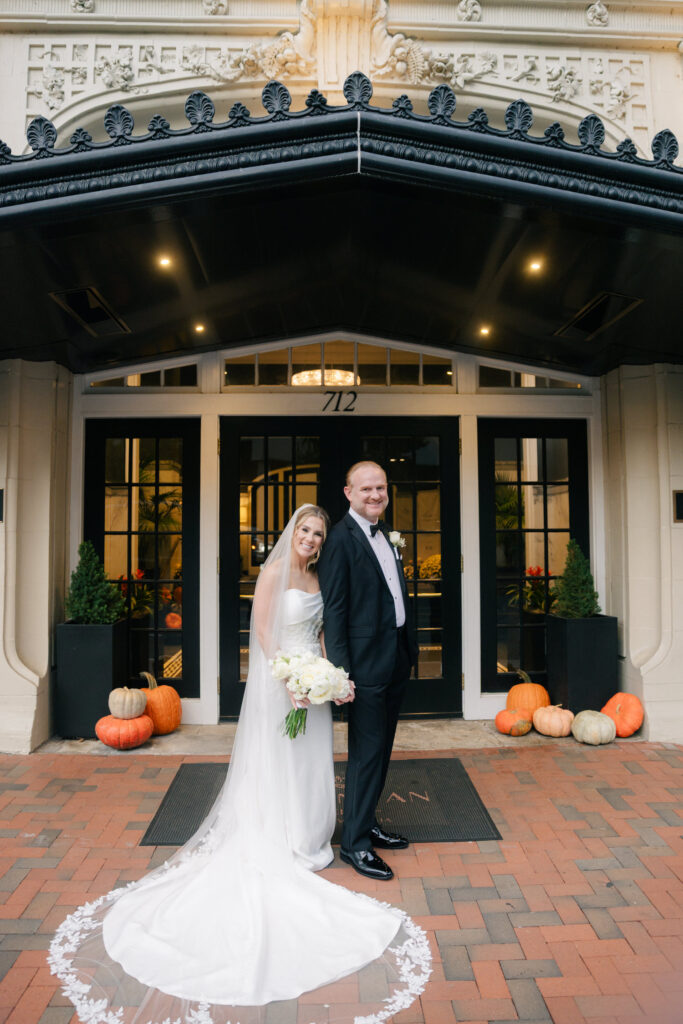 Newlyweds posing together under the entrance canopy at The Virginian Hotel in Lynchburg following their wedding ceremony