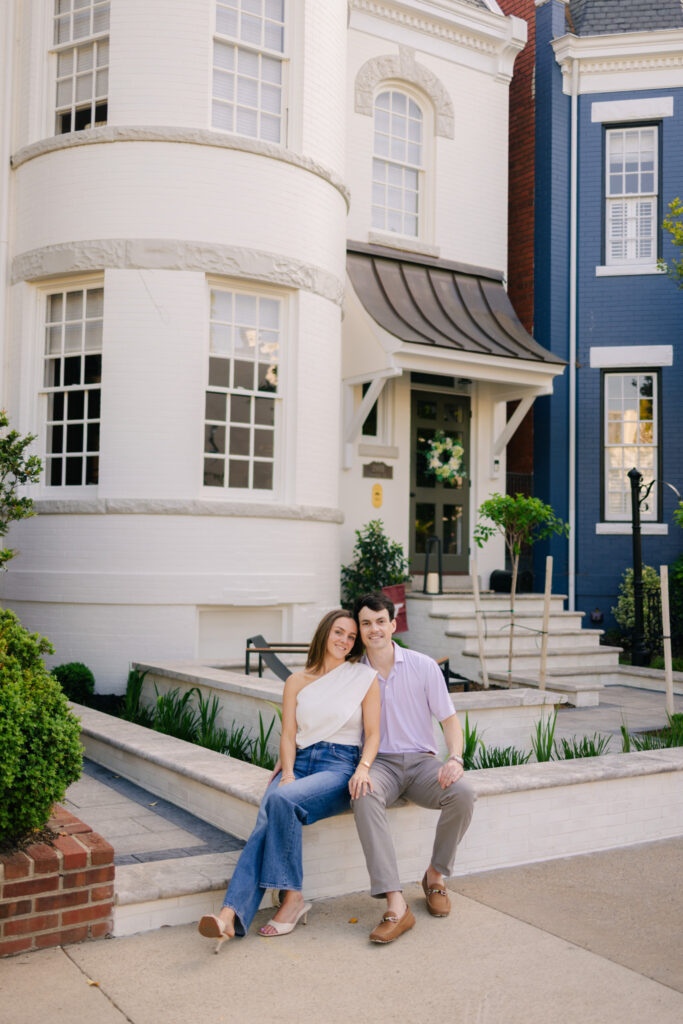 Couple seated together in front of historic townhouse during Downtown Richmond engagement photos by Pat Cori Photography
