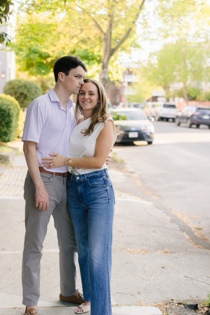 Couple embracing on a quiet tree-lined sidewalk during Downtown Richmond engagement session