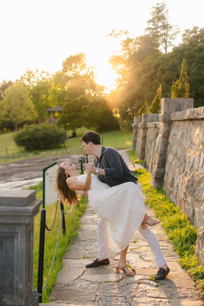 Playful couple dancing on stone pathway at sunset during Maymont engagement session by Pat Cori Photography