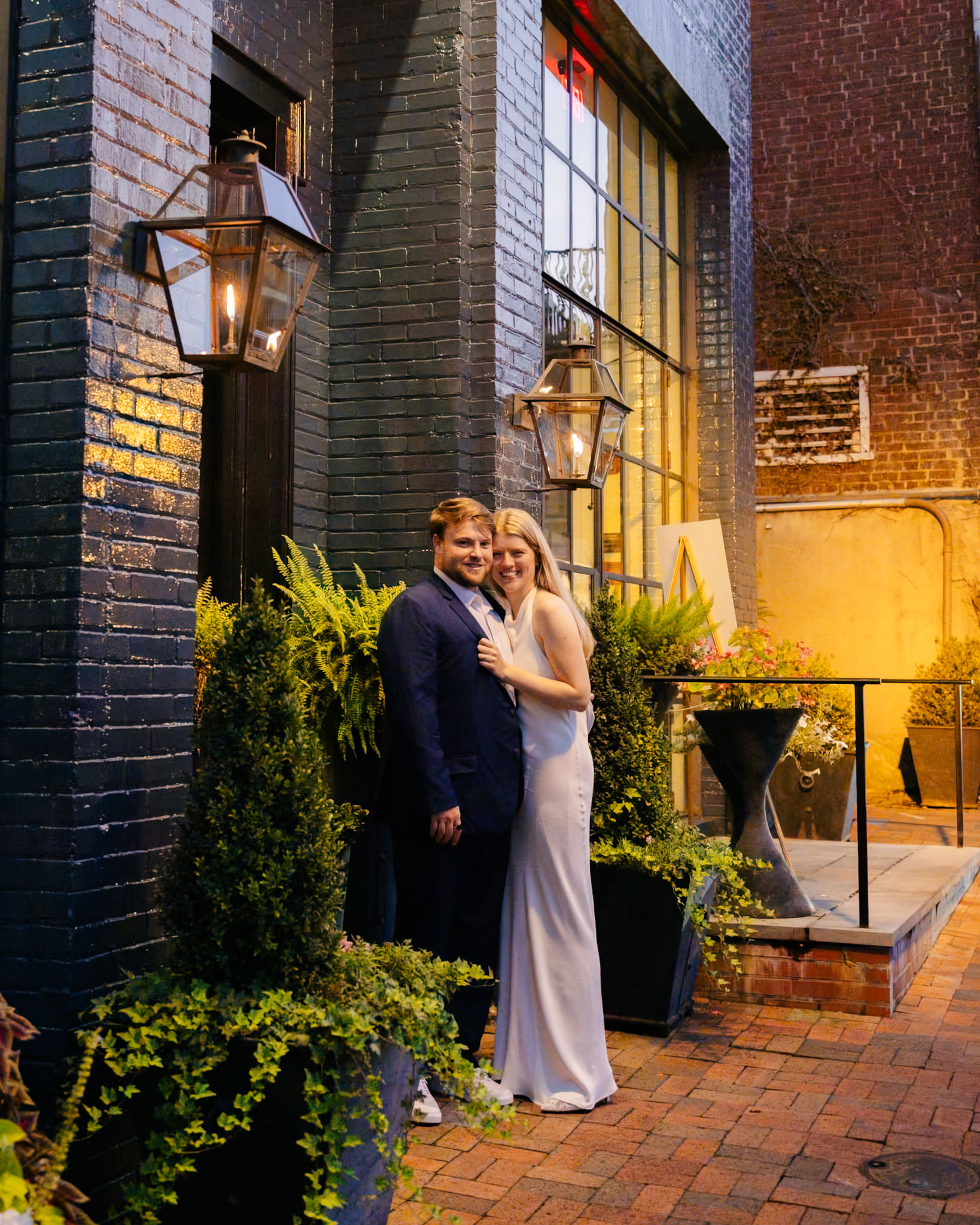 Bride and groom posing together outside The Georges in Lexington, Virginia, during their rehearsal dinner celebration