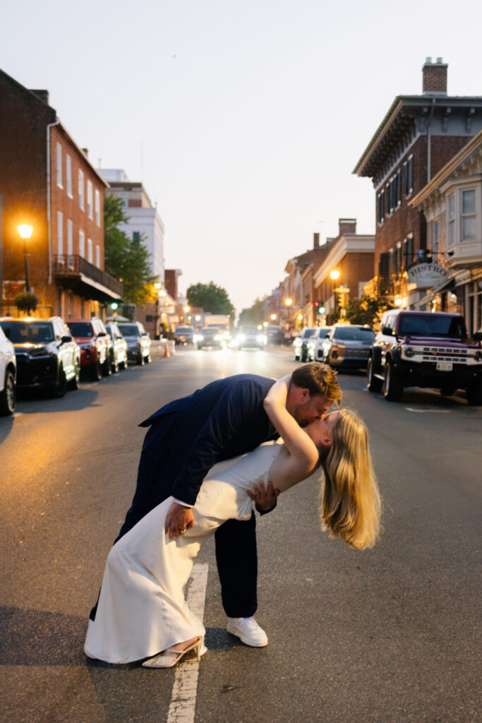 Bride and groom sharing a playful kiss in the middle of a downtown Lexington, Virginia street at dusk
