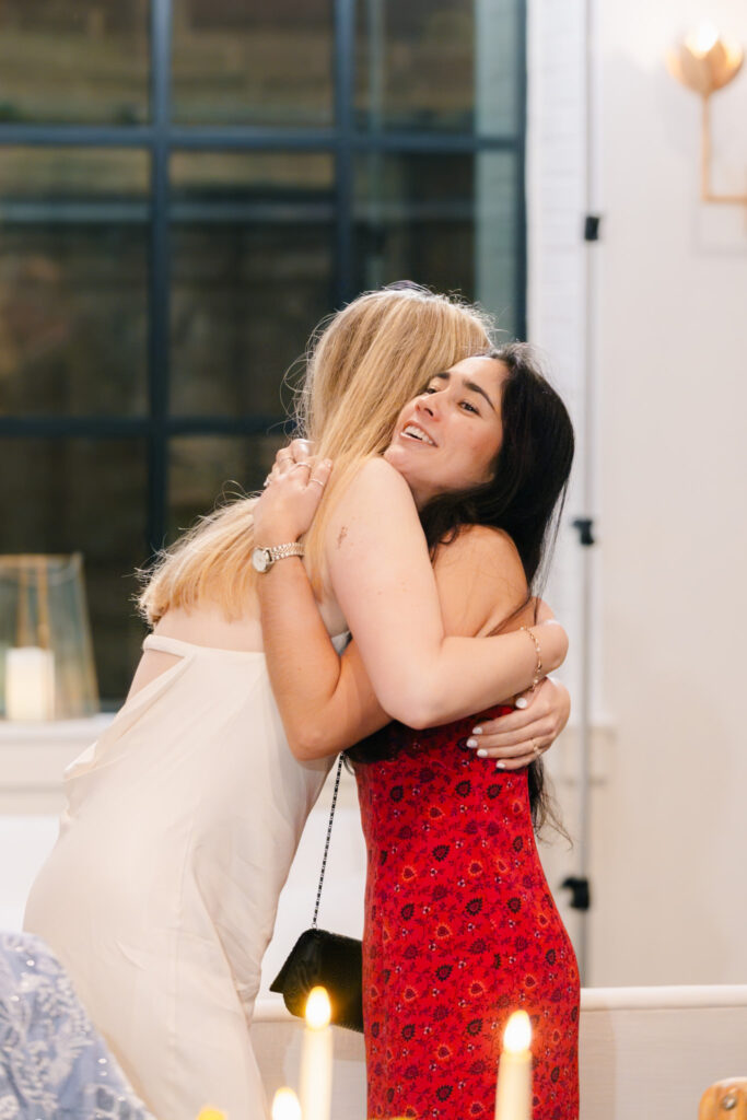 Bride sharing an emotional hug with a guest during the evening celebration.