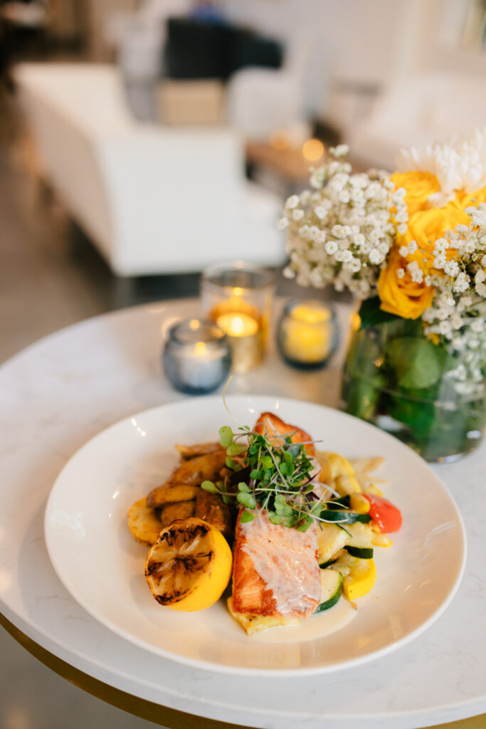 Close-up of bright yellow flowers and candlelight used as simple rehearsal dinner table décor at The Georges in Lexington, Virginia