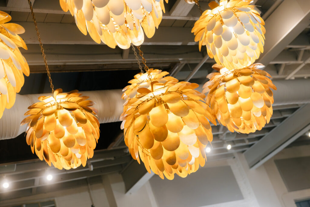 Glowing gold statement pendant lights inside The Georges during a rehearsal dinner in Lexington, Virginia.
