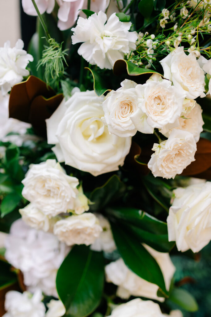 Close-up of elegant white roses and textured white flowers with deep green and magnolia foliage at an Alexandria wedding