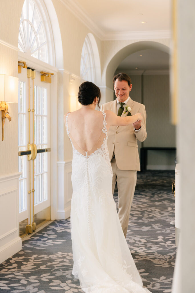 Bride and groom smiling and holding hands during their first look at The Alexandrian Hotel in Alexandria, Virginia