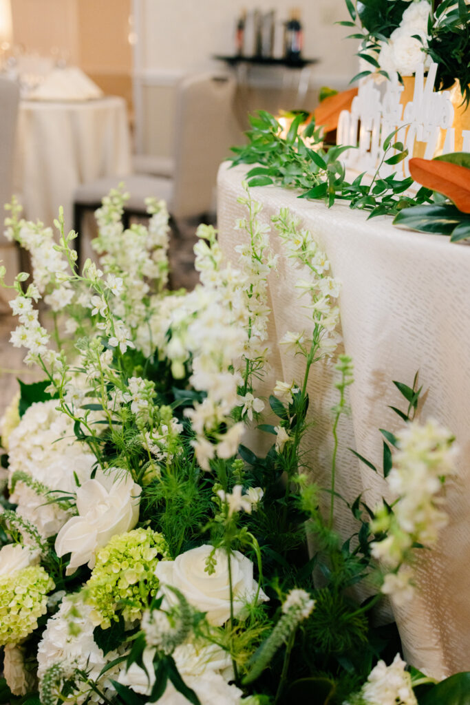 Lush white and green floral arrangement with roses and hydrangeas decorating the sweetheart table at The Alexandrian Hotel wedding in Alexandria, Virginia