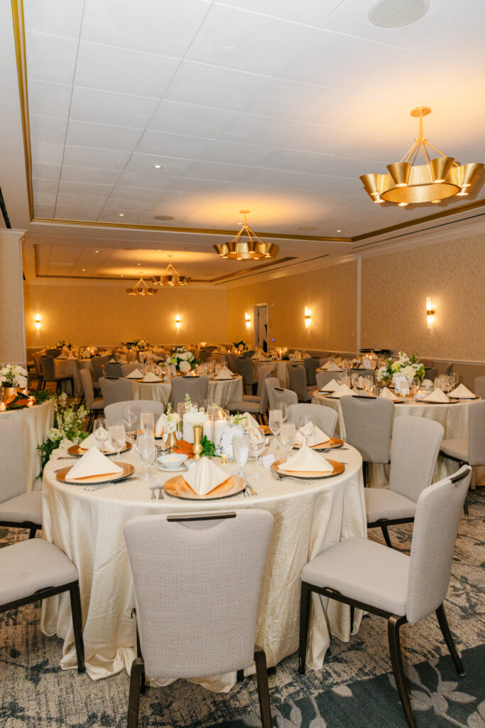 Alexandrian Hotel wedding reception in Alexandria, Virginia featuring ivory tables, white floral centerpieces and warm gold lighting
