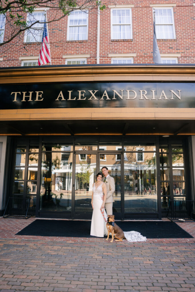 Bride and groom with their dog outside The Alexandrian Hotel on King Street in Old Town Alexandria